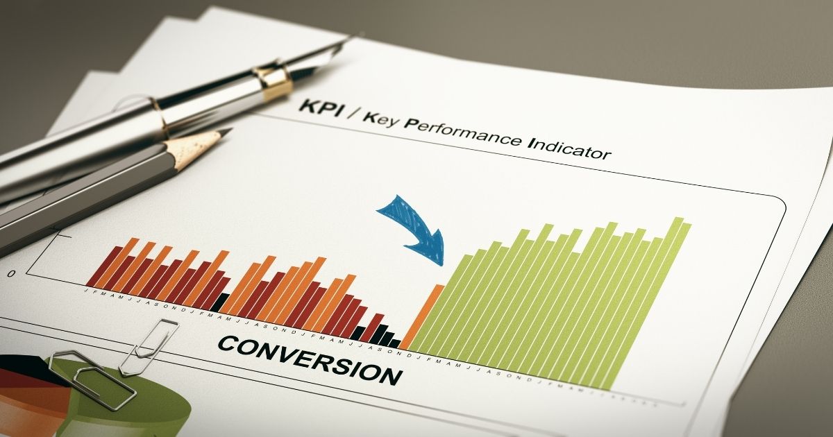 Blatt mit Balkendiagramm zum Key Performance Indicator Conversion, auf dem Blatt liegen ein Füller, ein Bleistift und Büroklammern